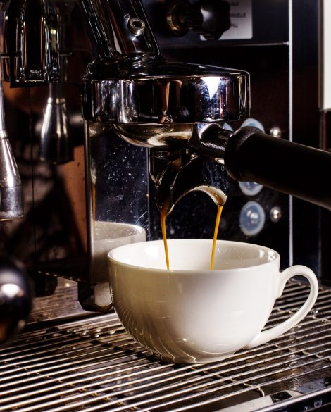 white cup under coffee mashine