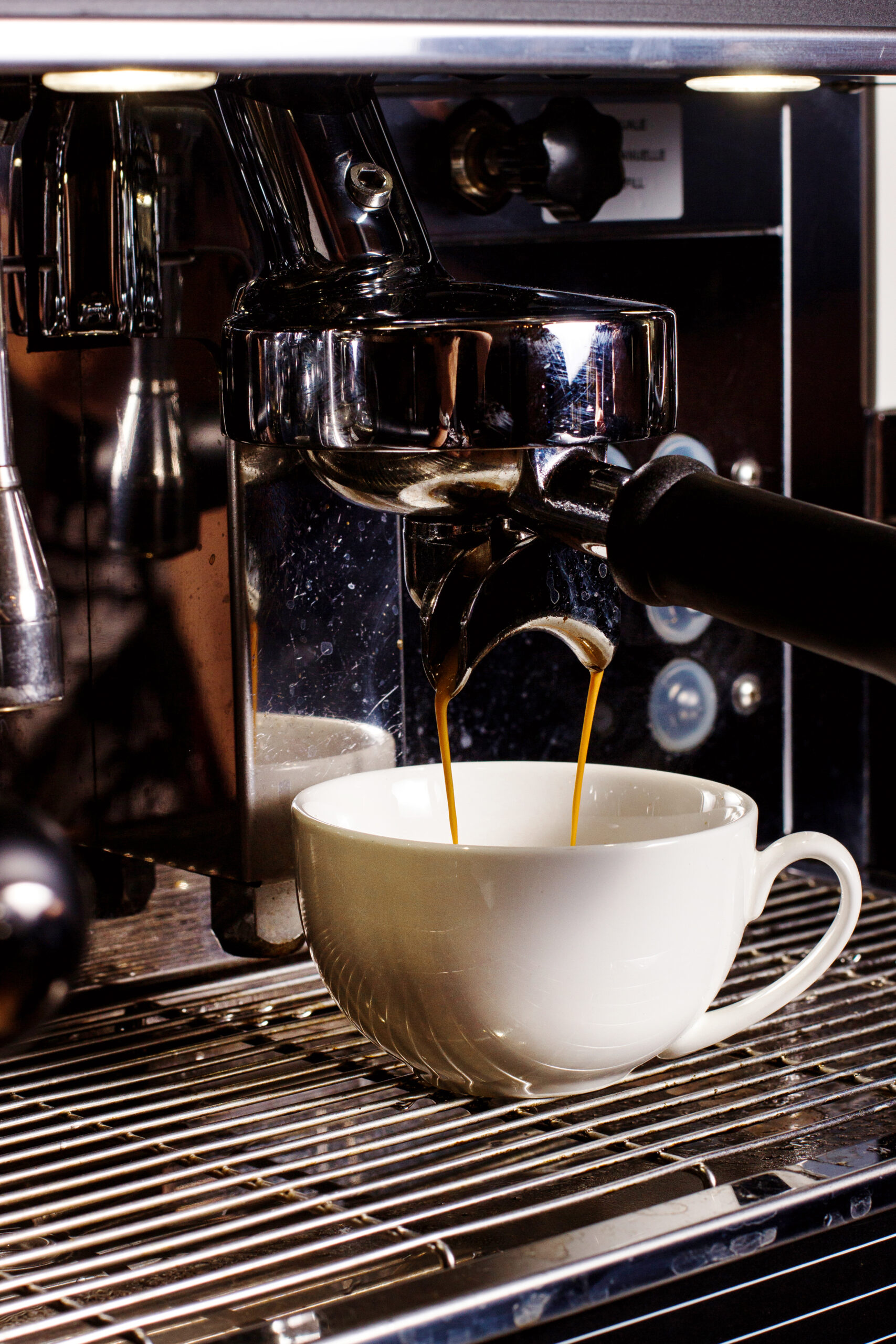 white cup under coffee mashine